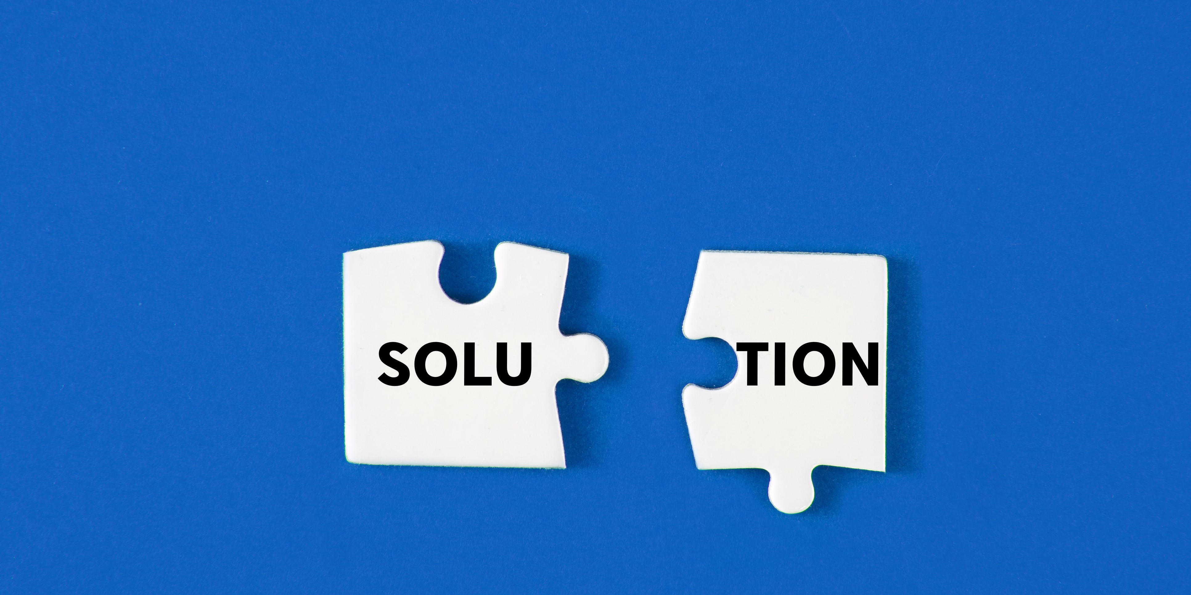 The word solution in black on white puzzle pieces that are about to be put together